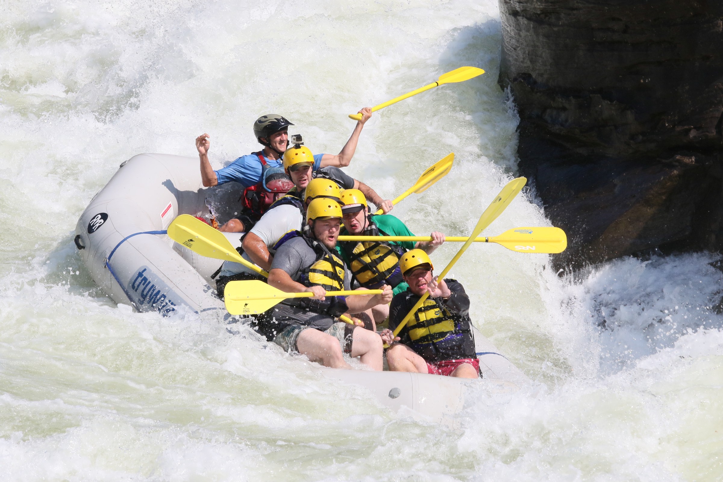 a man riding a surfboard on a raft in a body of water