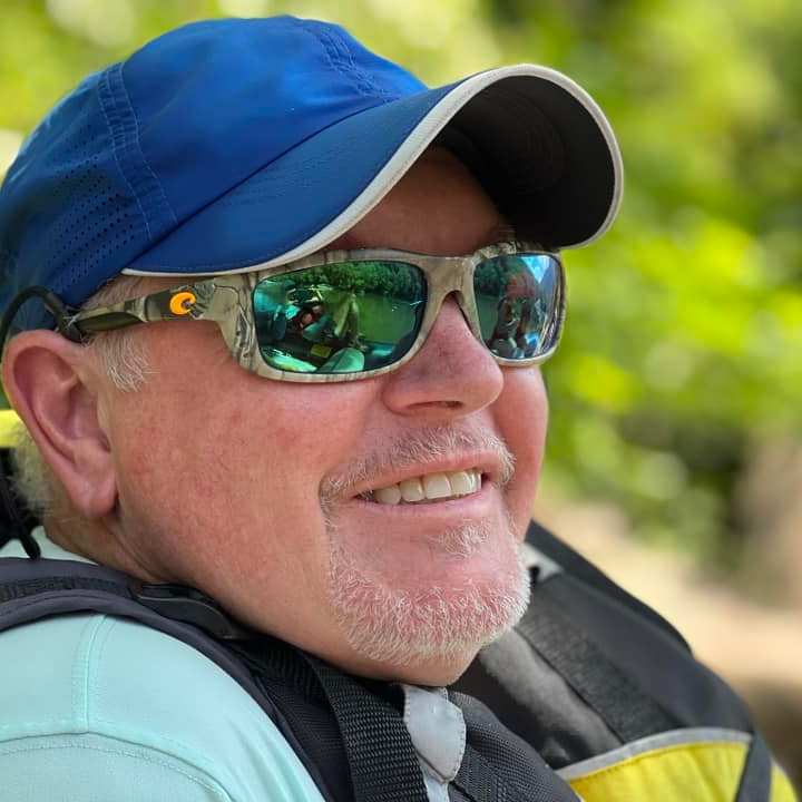 a man wearing a hat and sunglasses