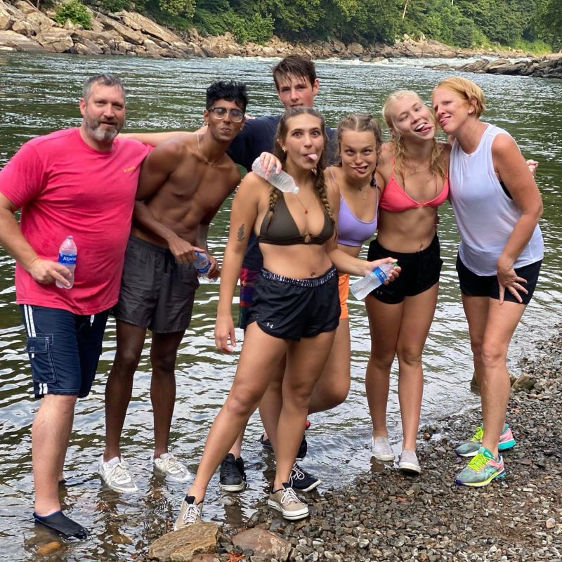 a group of people standing next to a lake
