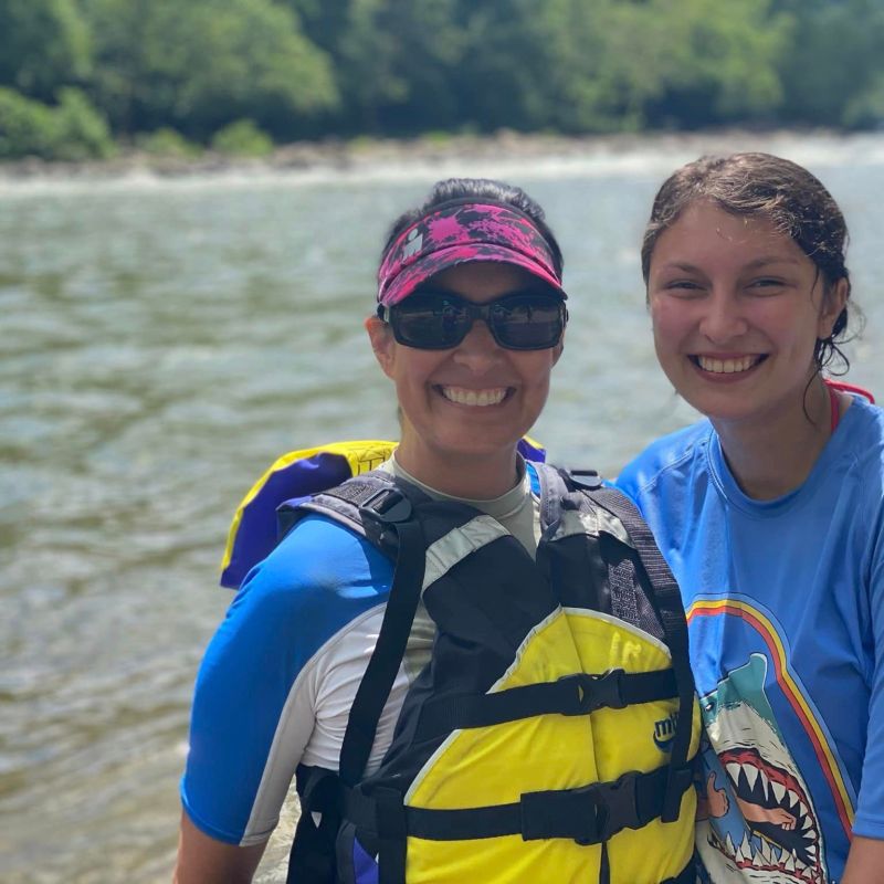 a man and a woman standing next to a body of water