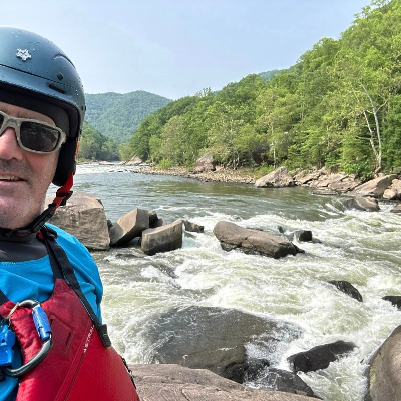 a man standing next to a river