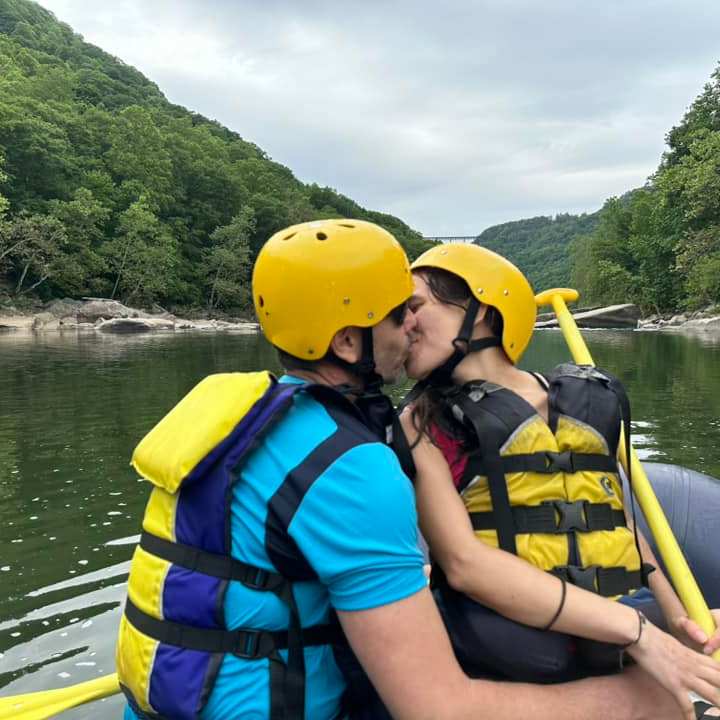 a person with a helmet on a raft in a body of water