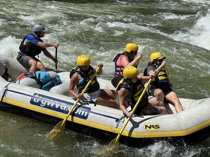 a group of people riding on a raft in a body of water