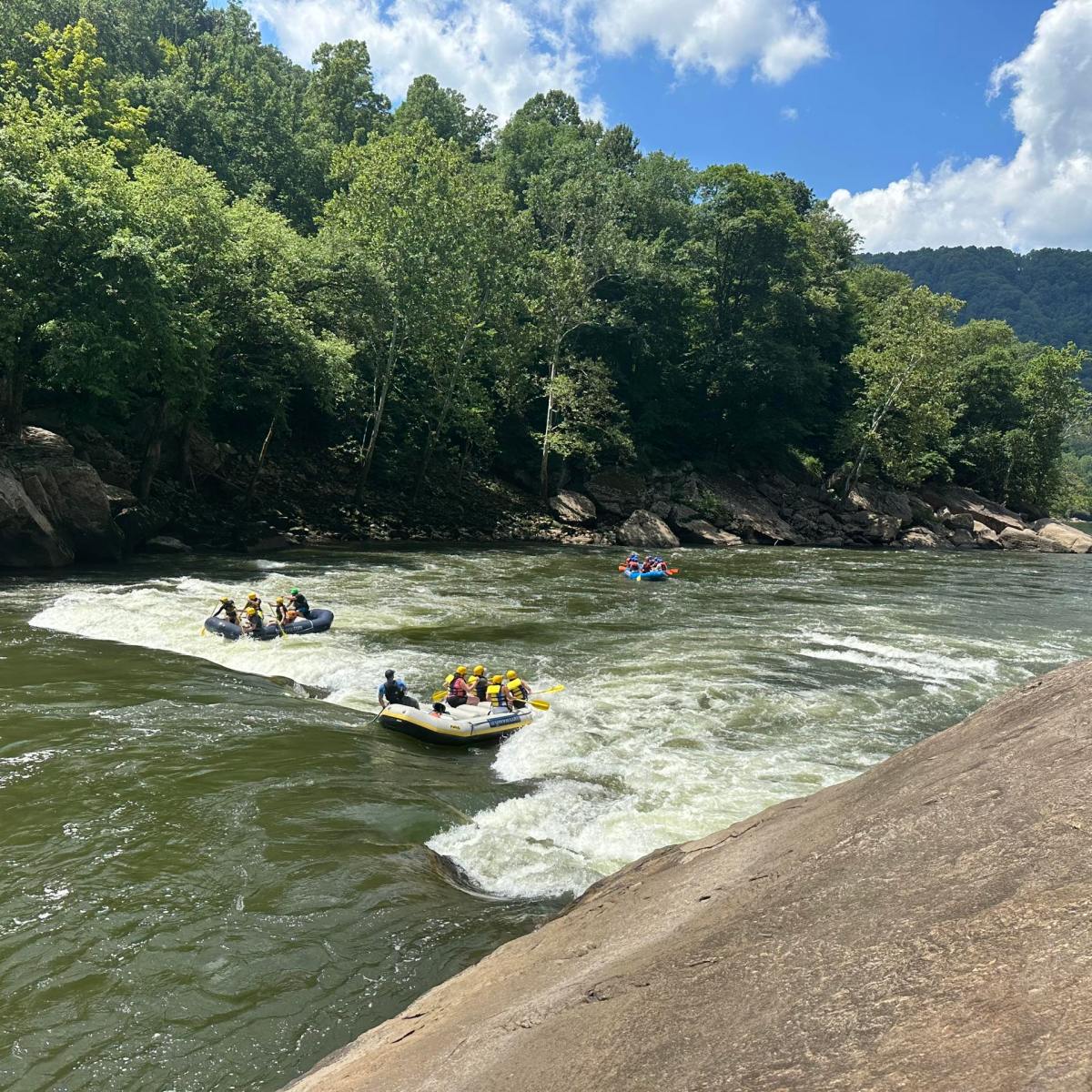 a group of people riding on the back of a boat in the water