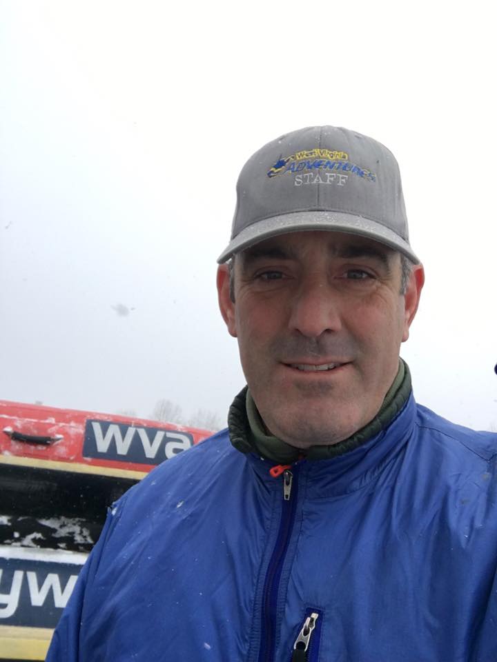 a man wearing a blue hat holding a fish