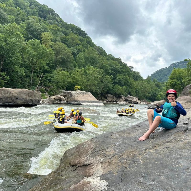 a young boy riding a skateboard up the side of a river