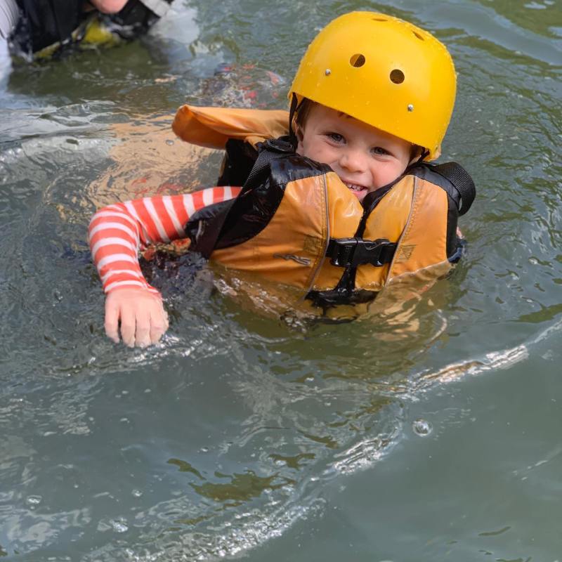 a young boy swimming in a body of water