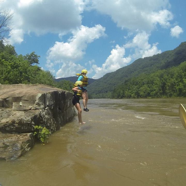 a man standing on a rock in the water