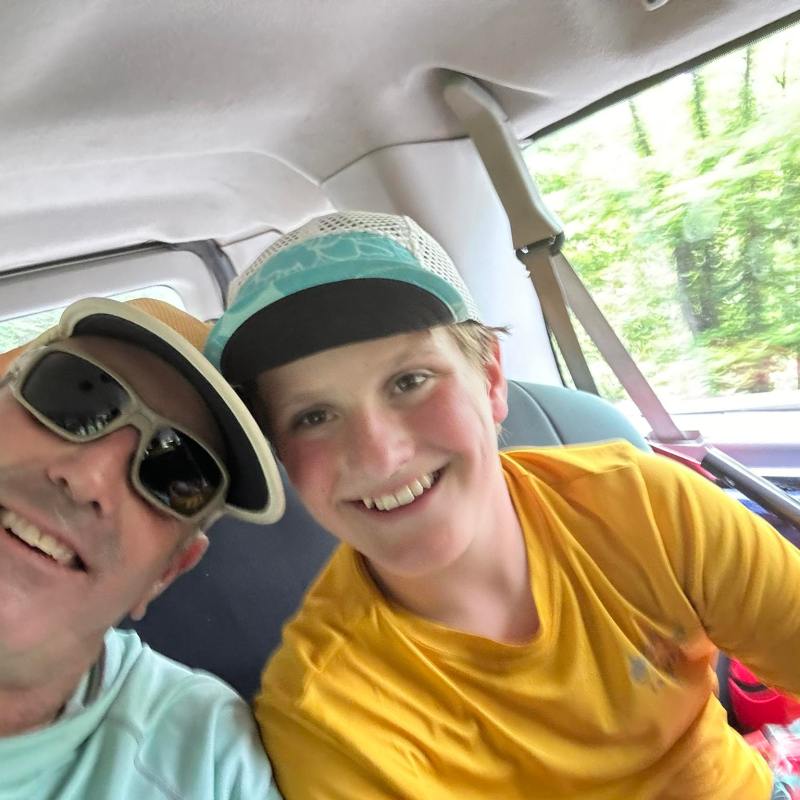 a person wearing sunglasses driving a car