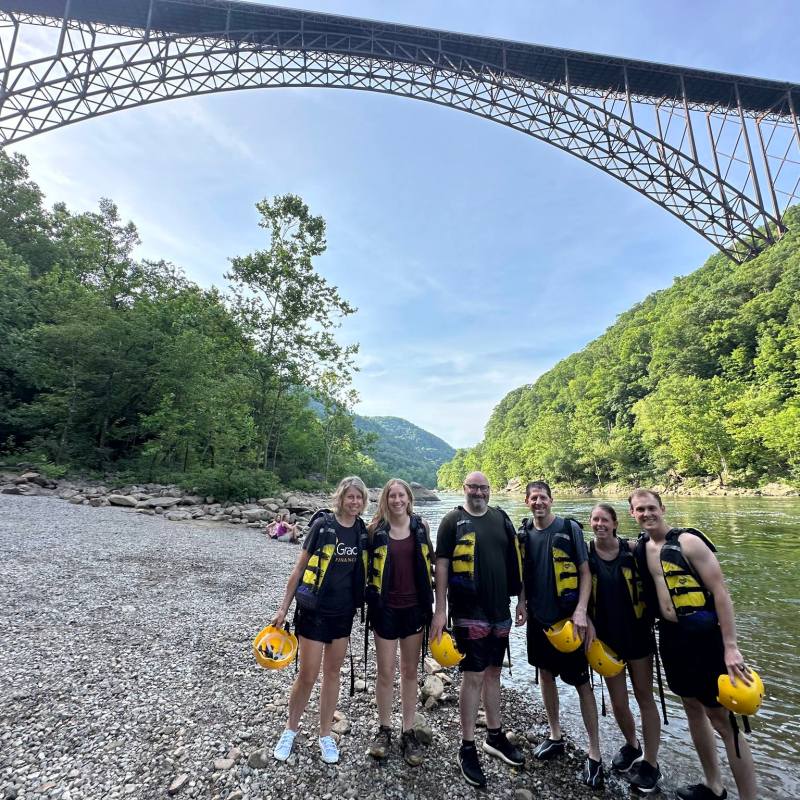 a group of people crossing a bridge over a body of water