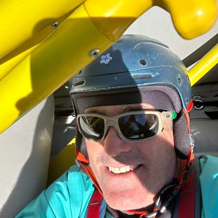 a man wearing sunglasses taking a selfie in a car