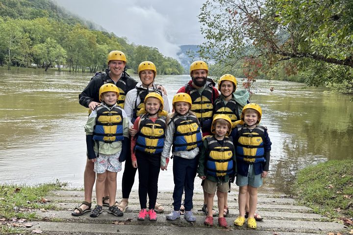 a group of people standing next to a river