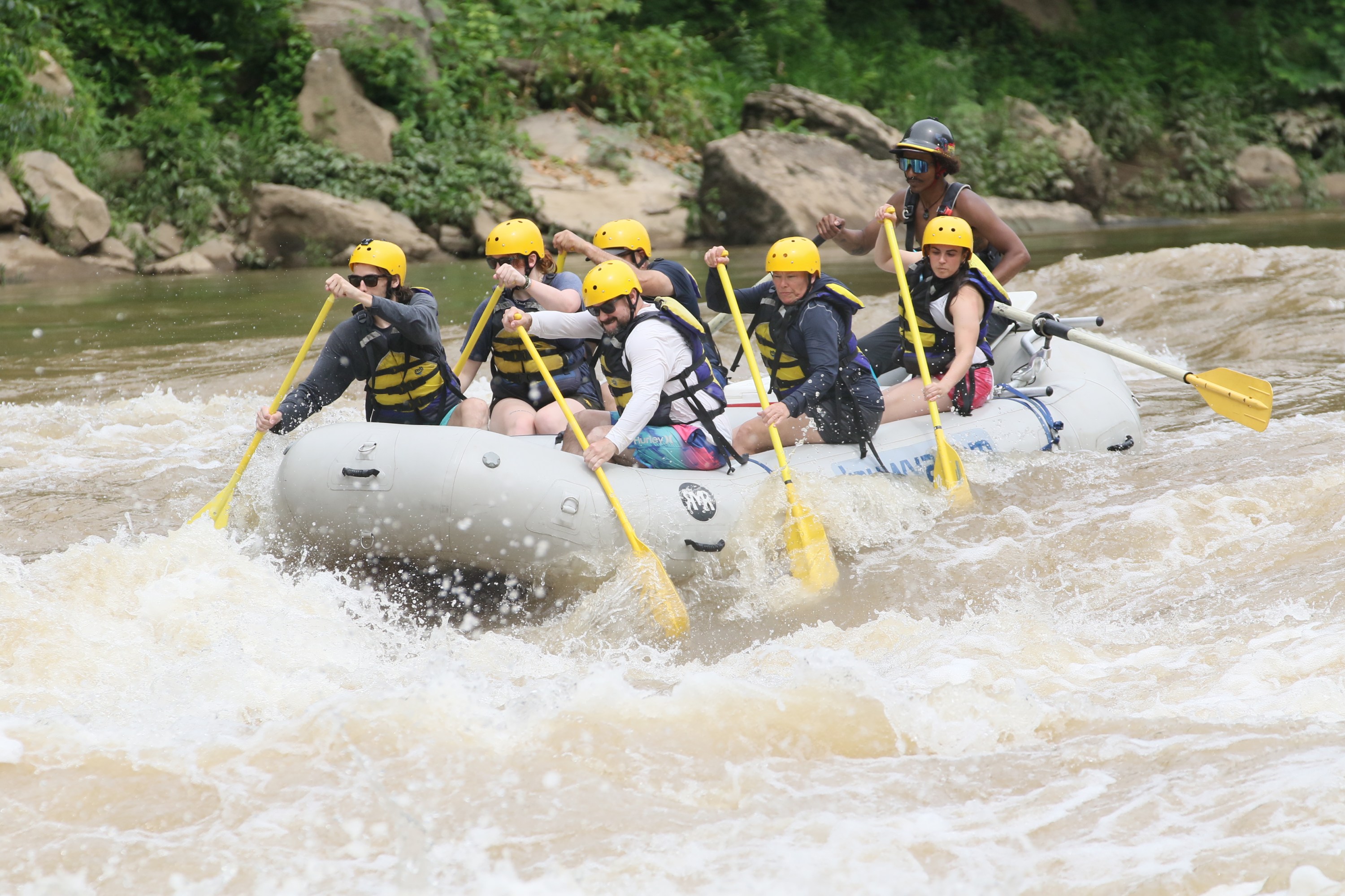 a group of people riding skis on a raft in the water