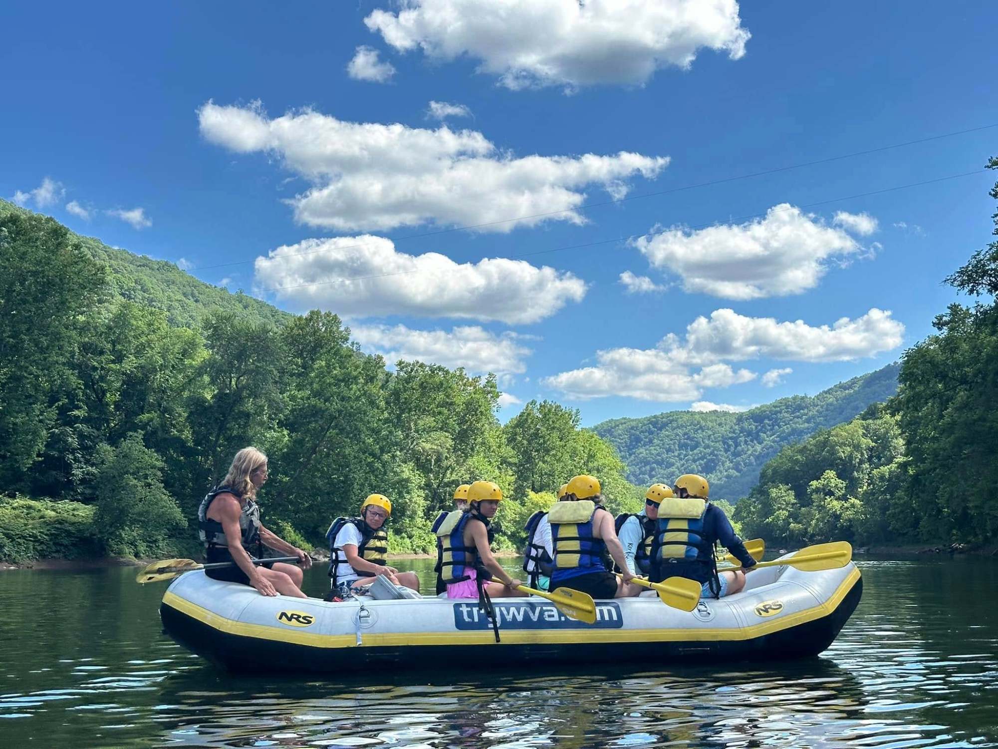 a group of people riding on the back of a boat in the water