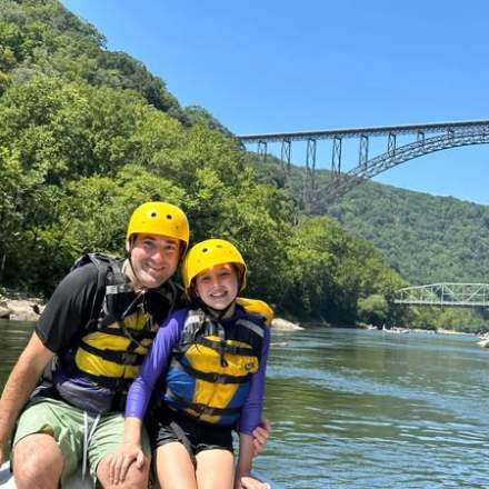 a boy standing next to a body of water