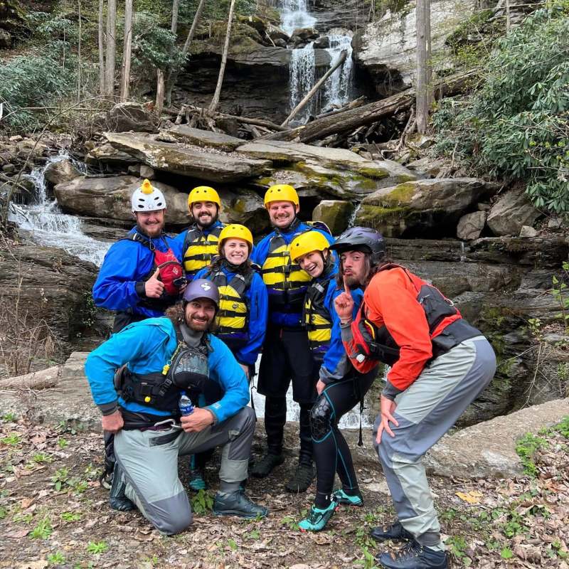 a group of people standing next to a tree