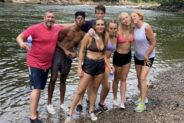 a group of people standing next to a body of water