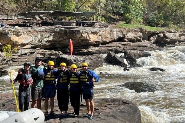 a group of people standing next to a river