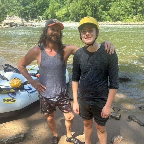 a group of people posing for a picture next to some water