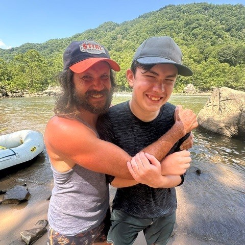 a man standing next to a river